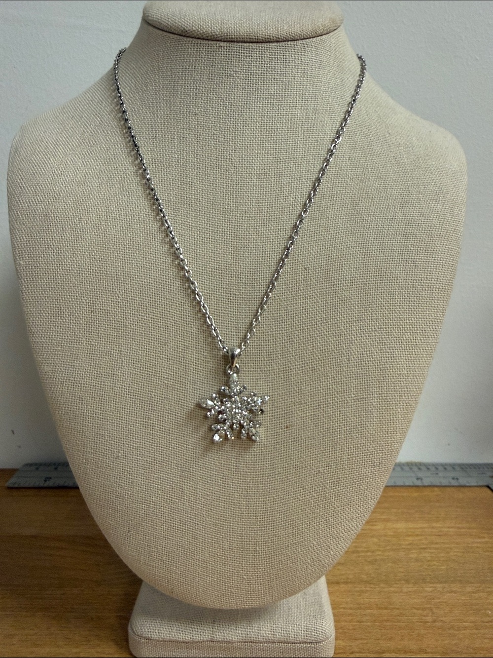 Silver tone rhinestone embellished snowflake pendant on chain
